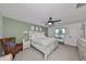 Main bedroom with a king-size bed, ceiling fan, and access to the en-suite bathroom at 5429 Rainwood Meadows Dr, Apollo Beach, FL 33572