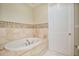 Elegant bathroom with oval soaking tub and beige tile at 700 N Osceola Ave # 702, Clearwater, FL 33755