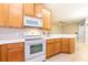 Kitchen features light wood cabinets and white appliances at 12820 Belvedere Song Way, Riverview, FL 33578