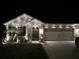 Well-lit home at night with landscaping and two-car garage at 1523 Glen Grove Loop, Wesley Chapel, FL 33543