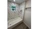 Updated bathroom with bathtub and marble tile at 1574 Ewing Ave, Clearwater, FL 33756