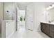 Bright bathroom boasts double sinks, a walk-in shower, and tile flooring at 6179 Hidden Branch Dr, Apollo Beach, FL 33572