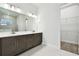 Double vanity bathroom with dark brown cabinets and walk-in closet at 6179 Hidden Branch Dr, Apollo Beach, FL 33572