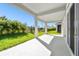 Spacious covered patio with lush landscaping and grassy backyard at 6179 Hidden Branch Dr, Apollo Beach, FL 33572