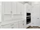 White kitchen cabinets and countertops with built-in wall oven and microwave at 6179 Hidden Branch Dr, Apollo Beach, FL 33572
