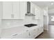 Modern kitchen with white cabinets, gas cooktop, and stainless steel range hood at 6179 Hidden Branch Dr, Apollo Beach, FL 33572
