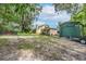 House with a large backyard, green metal garage, and gravel driveway at 10824 Palmetto St, Riverview, FL 33569