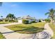 Side view showcasing a well-maintained lawn and a three car garage at 8929 Cashella Ct, Trinity, FL 34655