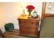 Wooden nightstand with three drawers, lamp, and flowers at 5909 Menorca Ln, Apollo Beach, FL 33572