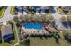 Aerial view of a community pool with lounge chairs, trees, and a nearby building at 2944 Prairie Iris Dr, Land O Lakes, FL 34638