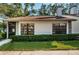 White exterior house with green landscaping and a brown roof at 3508 Magnolia Ridge Cir # 301, Palm Harbor, FL 34684