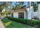 White house exterior with dark windows and a manicured lawn at 3508 Magnolia Ridge Cir # 301, Palm Harbor, FL 34684