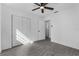 A bedroom featuring wood-look floors, a ceiling fan, closet, and a view into another room at 541 E Lime St, Tarpon Springs, FL 34689