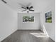 Bedroom featuring neutral walls, wood-look floors, a ceiling fan, and natural light from the windows at 541 E Lime St, Tarpon Springs, FL 34689