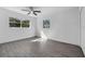 A bedroom with wood-look floors, a ceiling fan, and two windows letting in natural light at 541 E Lime St, Tarpon Springs, FL 34689