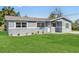 Charming gray home with a well-manicured lawn and front yard landscaping at 541 E Lime St, Tarpon Springs, FL 34689