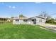 Charming gray home with a well-manicured lawn and front yard landscaping at 541 E Lime St, Tarpon Springs, FL 34689