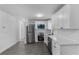 Bright kitchen featuring stainless steel appliances, white cabinets, and modern gray flooring at 541 E Lime St, Tarpon Springs, FL 34689