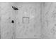 Walk-in shower showcases marble tiling, a shower niche and a black shower head at 541 E Lime St, Tarpon Springs, FL 34689