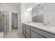 Bathroom showcasing a double vanity, a glass-enclosed shower, and neutral tile flooring for a clean, modern aesthetic at 2719 Winding Creek Trl, North Port, FL 34289