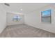 Spacious bedroom with neutral carpet, natural light from two windows, and a view of the neighborhood at 2719 Winding Creek Trl, North Port, FL 34289