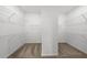 Walk-in closet with white shelving offering ample storage space, complemented by neutral carpeting at 2719 Winding Creek Trl, North Port, FL 34289