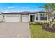 Beautiful single-story home featuring a three-car garage and a well-manicured front yard and paver driveway at 2719 Winding Creek Trl, North Port, FL 34289