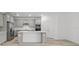 Bright kitchen boasts gray cabinetry, a kitchen island, stainless steel appliances, and wood flooring at 2719 Winding Creek Trl, North Port, FL 34289