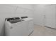 Convenient laundry room features tile flooring, washer, dryer, and overhead shelving at 2719 Winding Creek Trl, North Port, FL 34289