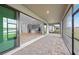 Covered patio with brick pavers leads into kitchen through sliding glass doors at 2719 Winding Creek Trl, North Port, FL 34289