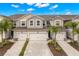 Charming townhouse showcasing a neutral palette, two-car garage, brick-paved drive, and manicured landscaping at 5018 Sunnyside Ln, Bradenton, FL 34211