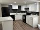 Modern kitchen with white cabinets, black appliances, and quartz countertops at 6969 Oldgate Cir, New Port Richey, FL 34655