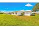 View of home's exterior and grassy backyard at 9125 39Th N Ln, Pinellas Park, FL 33782