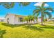 Side view of a white single story house with lush green landscaping at 9125 39Th N Ln, Pinellas Park, FL 33782