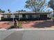 Single story home with a brick driveway, mature landscaping, and a mix of tan and brown exterior paint at 480 82Nd Ave, St Pete Beach, FL 33706