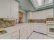 Kitchen with white cabinets and skylight at 8 Belleview Blvd # 408, Belleair, FL 33756