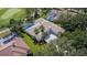 Aerial view of home with screened pool, tile roof, palm trees, and manicured landscaping at 9226 Highland Ridge Way, Tampa, FL 33647