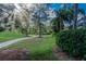 Serene backyard featuring a winding pathway, lush greenery, and mature trees, backing onto the golf course at 9226 Highland Ridge Way, Tampa, FL 33647