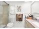 Bathroom featuring a shower with glass door, neutral tiles, and vanity with granite countertop at 5479 Pinehurst Dr, Spring Hill, FL 34606