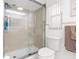 Bathroom featuring a shower with glass door, neutral tiles, and modern toilet at 5479 Pinehurst Dr, Spring Hill, FL 34606