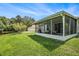 A screened-in porch area overlooks a pond and green backyard at 10954 May Apple Ct, Land O Lakes, FL 34638