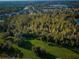 Drone view of a large lot with lush vegetation, bordering a residential area and lake at 11833 Castine St, New Port Richey, FL 34654