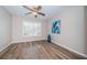 Bright bedroom with wood-look floors and ceiling fan at 11833 Castine St, New Port Richey, FL 34654