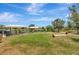 A grassy dog park with shaded benches, play structures, and a secure fence for safe outdoor recreation at 5502 Limelight Dr, Apollo Beach, FL 33572