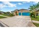 Two-story house with teal garage doors and landscaped yard at 5502 Limelight Dr, Apollo Beach, FL 33572