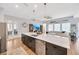 Open-concept kitchen with an island featuring a sink, dishwasher, and pendant lighting, seamlessly flowing into living area at 5502 Limelight Dr, Apollo Beach, FL 33572