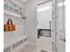 Mud room with a bench, hooks, and storage leading to the laundry room with gray tile flooring at 5502 Limelight Dr, Apollo Beach, FL 33572