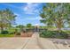 Scenic picnic area with tables and umbrellas, set behind a black metal fence and mature trees at 5502 Limelight Dr, Apollo Beach, FL 33572