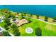 Aerial view of a community playground with swings, slides, and green space near a lake at 5502 Limelight Dr, Apollo Beach, FL 33572