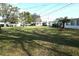 Spacious grassy backyard with mature trees and a glimpse of neighboring homes at 4254 96Th N Ter # Two, Pinellas Park, FL 33782